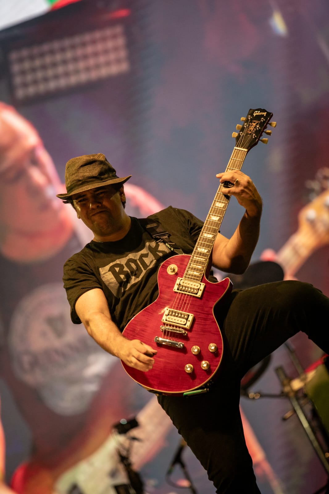 Guitarrista da Faixa Etária com guitarra vermelha no palco