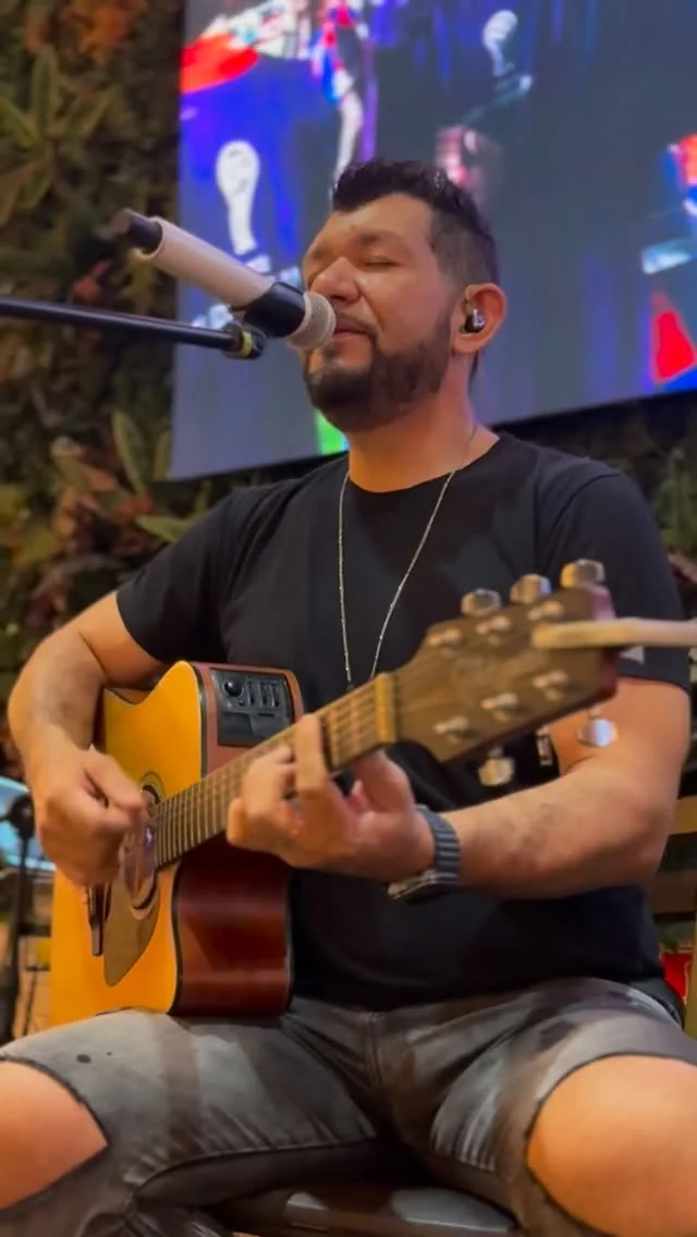 Adriano cantando com violão